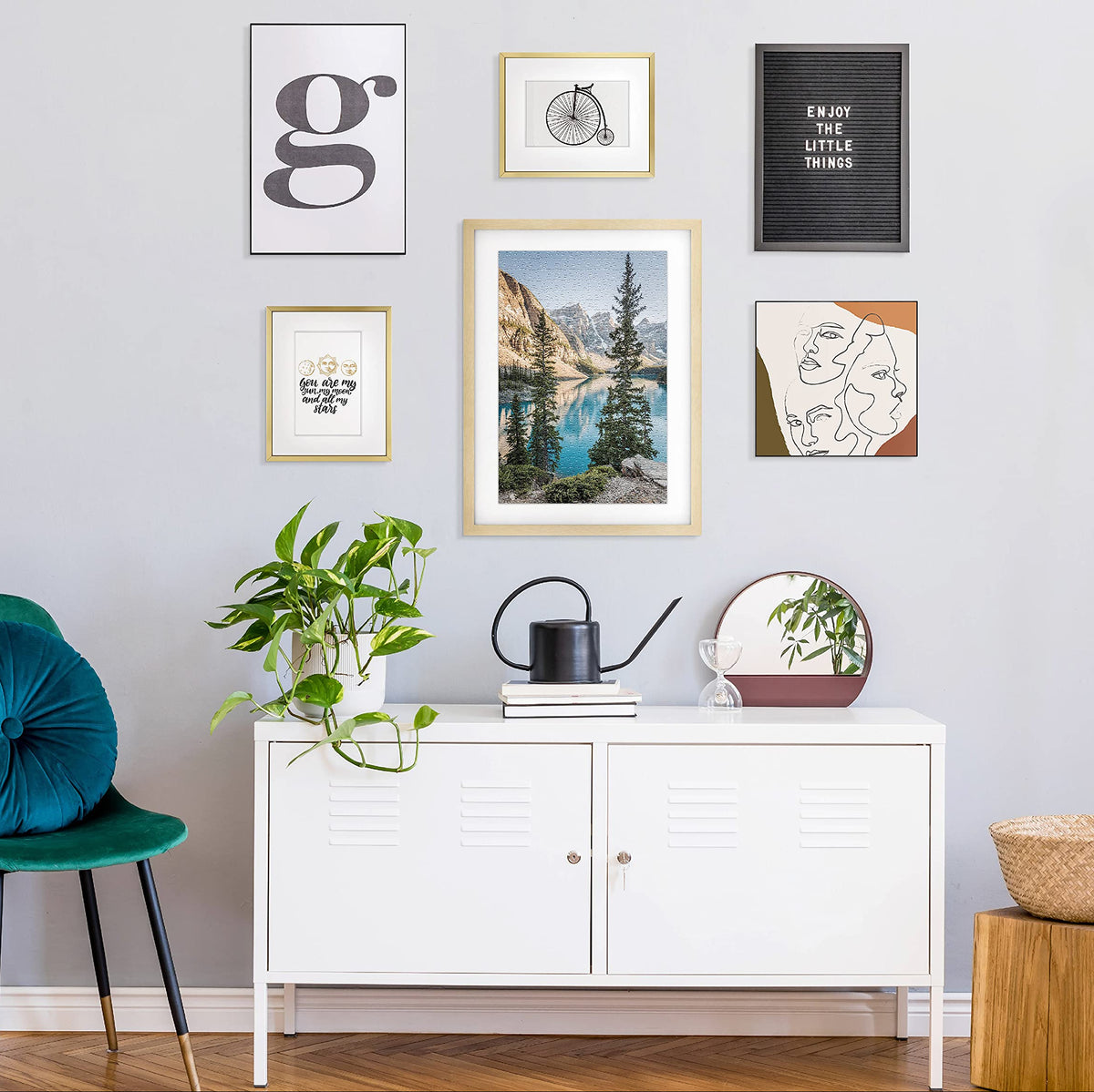 Living room with white cabinet, green chair, and various framed artworks on the wall.