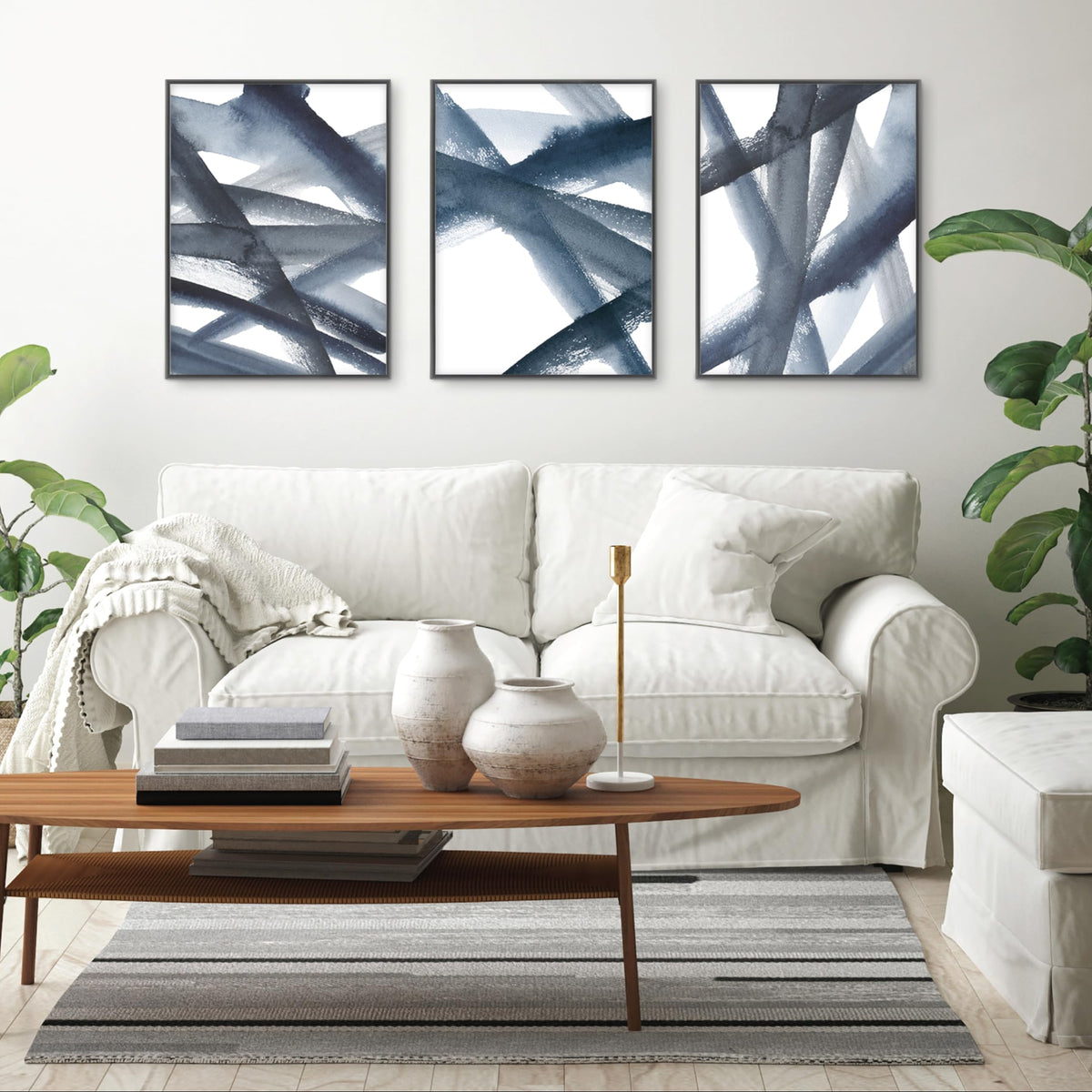 Living room with abstract wall art, white sofa, and wooden coffee table.
