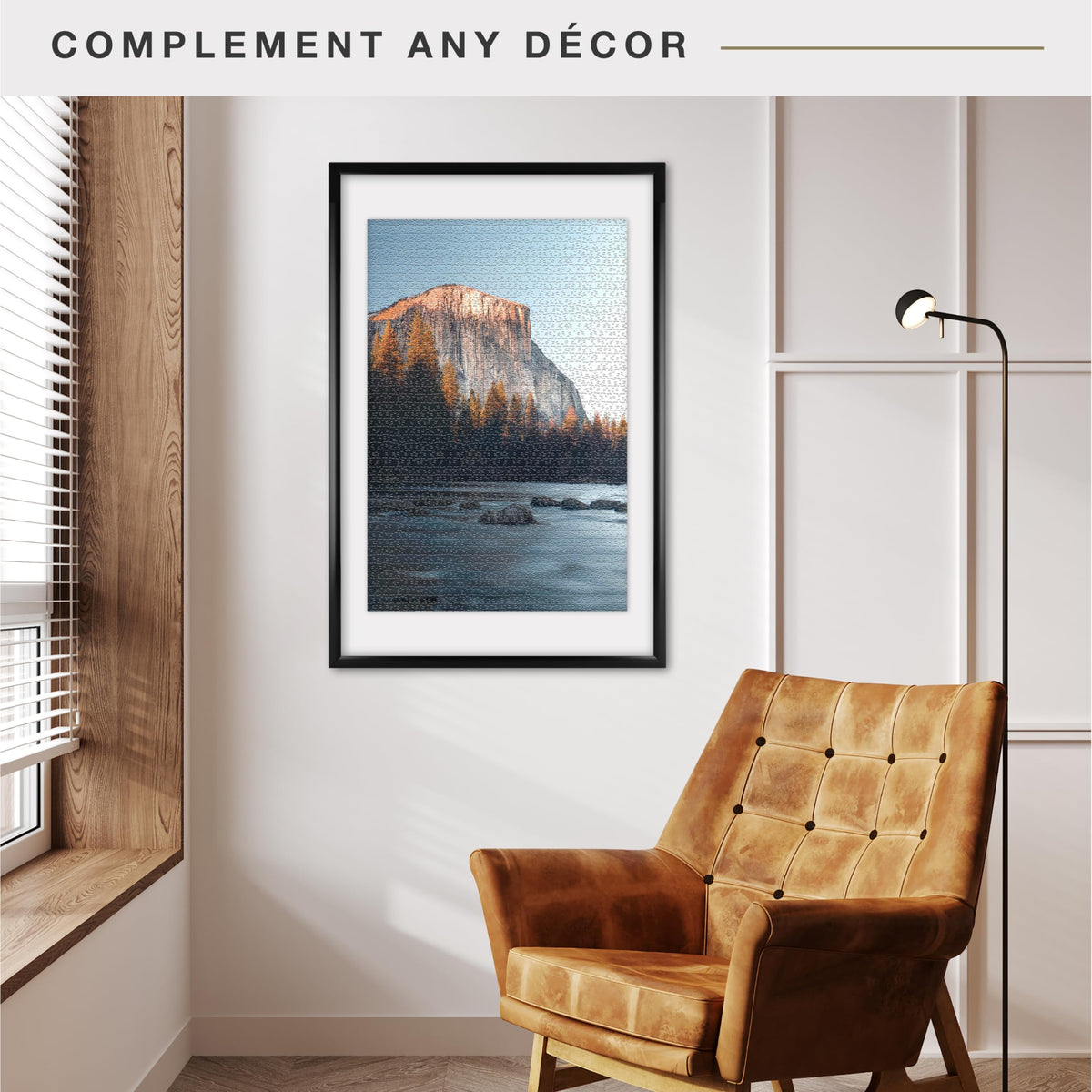 Brown leather armchair in a room with a framed landscape print on the wall.
