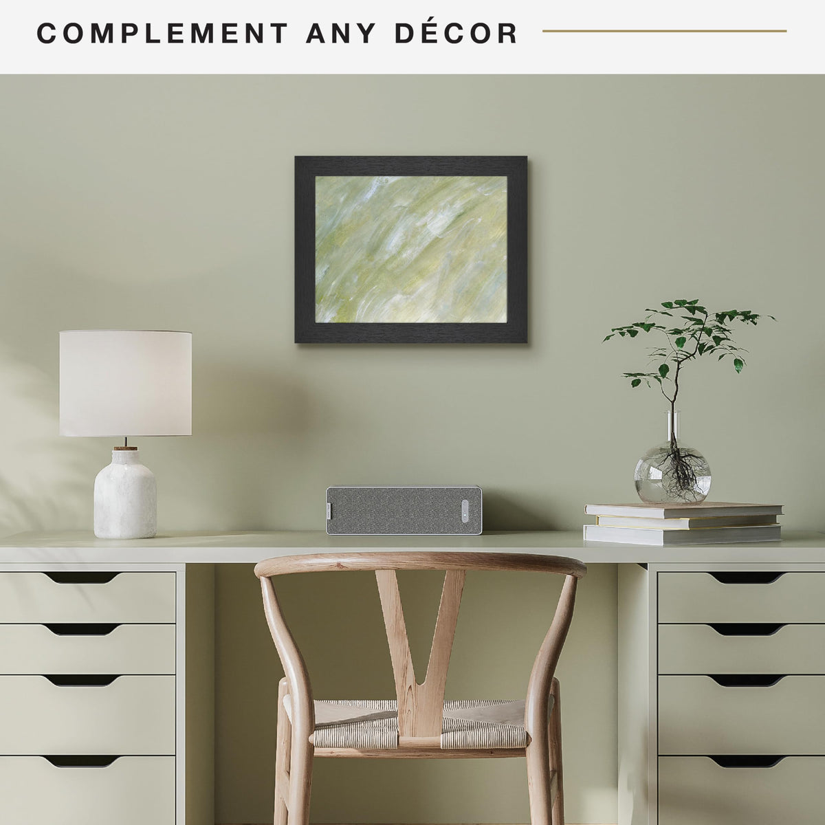 Modern office setup with a desk, chair, lamp, and decor items against a green wall.